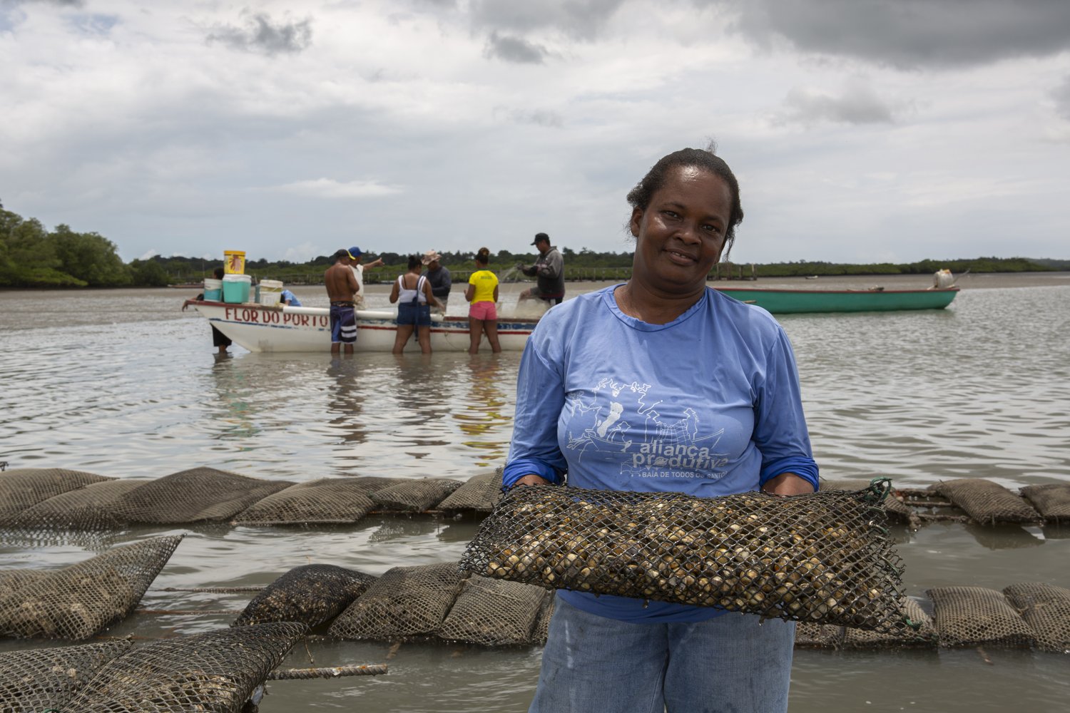 Lia, fisherwoman and mother, has started to grow shellfish with the help of a local NGO. She has seen her income and livelihood conditions improve in the last few years.Lia, pescadora e mãe, começou a cultivar marisco com a ajuda de uma ONG local. Ela viu sua renda e condições de subsistência melhorarem nos últimos anos.